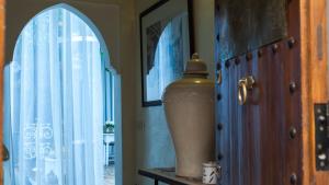 a vase sitting on a table next to a window at Riad Les Orangers D'alilia in Marrakesh