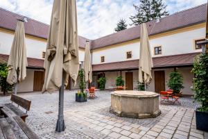 an outdoor courtyard with umbrellas and a tub at Limehome Krems Undstraße in Krems an der Donau