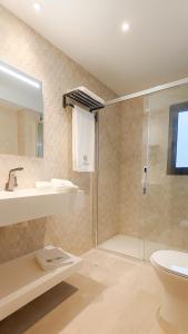 een badkamer met douche, wastafel en toilet bij Hotel Las Dunas in Somo +25 foto's