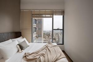 Un dormitorio con una cama blanca con una ventana grande. en Luxury The MarQ-Free Infinity Pool, GYM & BBQ-D1, en Ho Chi Minh