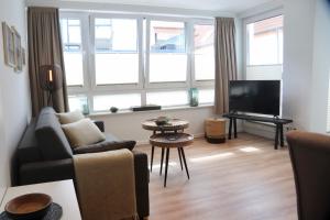 a living room with a couch and a tv at Ferienwohnungen Momentum Norderney in Norderney