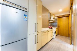 a kitchen with white appliances and a refrigerator at Bene International Hotel Zhujiang New Town US Consulate General Guangzhou Branch in Guangzhou