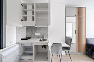 a kitchen with white cabinets and a desk and a chair at Central Cozy 1Bedroom Apartment with Sofa Bed - Sleeps 4 in Vilnius