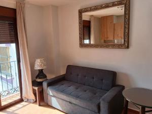 a living room with a couch and a mirror at weforyou Plza España Benalmádena in Benalmádena +1 photo