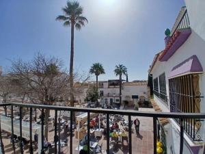 a view of a street with a palm tree and a building at weforyou Plza España Benalmádena in Benalmádena