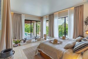 a bedroom with a large bed and large windows at Villa Morada Canggu by Nakula in Dalung +59 photos
