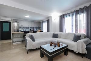 ein Wohnzimmer mit einer weißen Couch und einem Tisch in der Unterkunft Villa Valentino Swimming Pool in Moravë