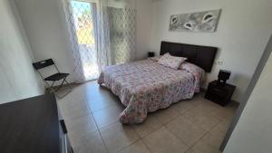a bedroom with a bed and a chair in it at Appartamento Altamar Las Americas in Playa de las Americas +25 photos