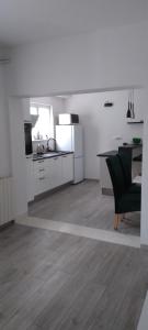 イェルサにあるApartment SEAVIEW Jelsa Račićの白いキッチン(テーブル、緑の椅子付)