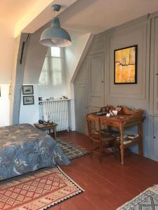 a bedroom with a desk and a bed at Les Pensées - Chambre Turner in Orléans
