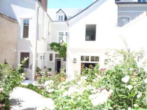 a white house with flowers in front of it at Les Pensées - Chambre Turner in Orléans