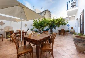 a patio with a table and chairs and an umbrella at Le Margherite in San Vito lo Capo