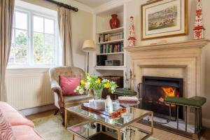a living room with a fireplace and a couch at Wychwood Cottage in Bruern