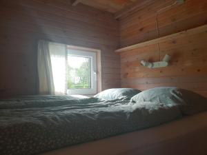 ein Schlafzimmer mit einem Bett vor einem Fenster in der Unterkunft Hytte C in Gråsten