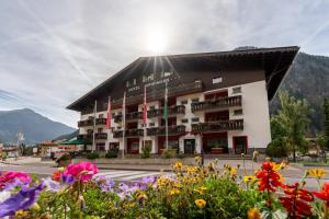 duży budynek z kwiatami przed nim w obiekcie Hotel Grohmann w mieście Campitello di Fassa
