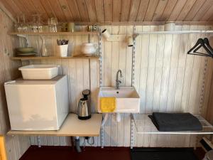 a small kitchen with a sink and a refrigerator at Rinkenæshus Hytte A in Gråsten