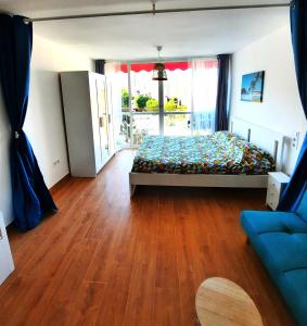 a bedroom with a bed and a wooden floor at Playmon Holiday Apartment in Benidorm +11 photos