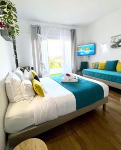 a bedroom with a bed and a large window at Hotel L'Escapade in Le Lavandou