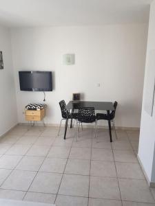 a dining room with a table and chairs and a tv at Loue studio in Corte