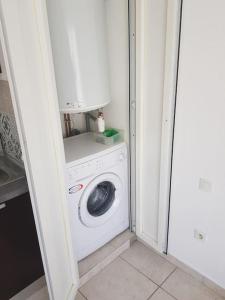 a washer and dryer in a small room with a door at Loue studio in Corte