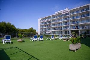 a group of chairs on a lawn in front of a hotel at Albatros Family in Salou