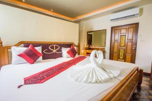 una habitación de hotel con una cama con un cisne en ella en The Siam Residence Boutique Resort, en Lipa Noi