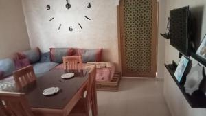 a living room with a couch and a table and a clock at تافوكة in Essaouira +12 photos