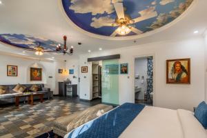 a living room with a bed and a ceiling at Sterling Marbella Dehradun in Dehradun