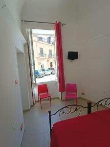 a room with two red chairs and a window at TETIDE Holiday home,casa vacanze in Trapani