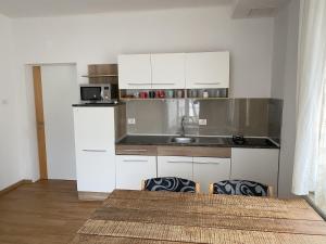 a kitchen with white cabinets and a sink at Lavender in Postojna