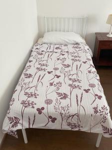 a bed with a white bedspread with flowers on it at Lavender in Postojna +30 photos