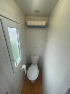 a small bathroom with a toilet and a window at Casă mobilă 1 in Constanţa +8 photos