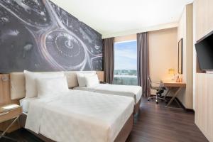 a hotel room with two beds and a tv at Swiss-Belhotel Airport Jakarta in Tangerang