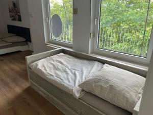 a bed sitting in a room with two windows at Schöne und sehr zentrale Wohnung im Herzen von Gelsenkirchen in Gelsenkirchen +3 photos