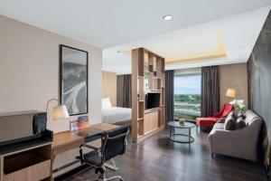 Swiss-Belhotel Airport Jakarta في تانغيرانغ: غرفة فندقية مع سرير وغرفة معيشة