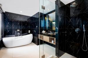 a bathroom with a tub and a sink at Swiss-Belhotel Airport Jakarta in Tangerang