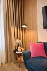 a living room with a blue couch and a pink pillow at Rina Apartments in Sarajevo +65 photos