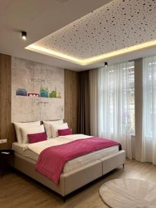 a bedroom with a large bed with pink sheets at Rina Apartments in Sarajevo