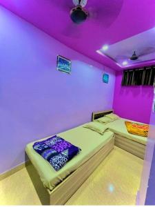 two beds in a room with purple lighting at Kesar Guest House Usri Gate Ajmer in Ajmer