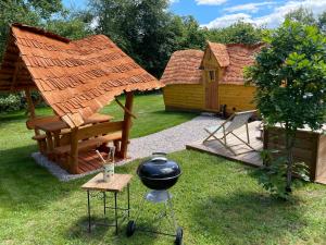 een achtertuin met een prieel en een grill bij Cabane Insolite Cosy in Ramonchamp