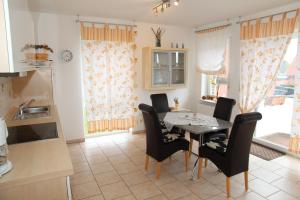 a kitchen and dining room with a table and chairs at Jantje in Norddeich