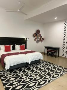 a bedroom with a large bed and a black and white rug at Tabokana House in Victoria Falls