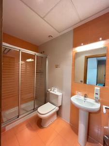 a bathroom with a toilet and a sink and a shower at Hostal Aralar in Aizoáin +24 photos