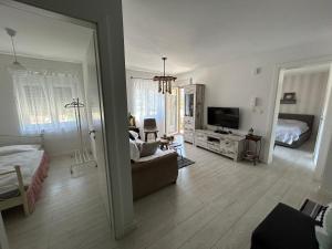een woonkamer met een bank en een bed bij Apartment Timka in Mostar