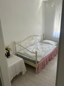 een slaapkamer met een wit bed met een roze rok bij Apartment Timka in Mostar