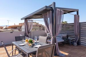 ナフプリオにあるFD Luxury Suitesのバルコニーにテーブルと椅子が置かれたパティオ