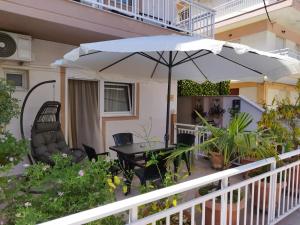 パラリア・カテリニスにあるHotel Villa Pigasosの傘とテーブルと椅子のあるパティオ