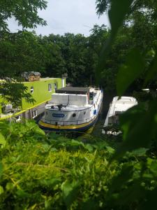 a boat is parked next to a house at Peniche refuge Seine in Vigneux-sur-Seine