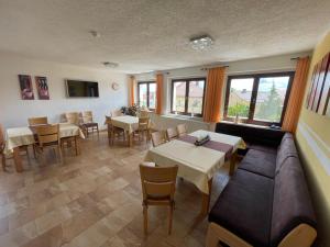 a restaurant with tables and chairs and a couch at Gästezimmer zum Sonnenhof in Zahna-Elster