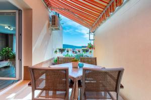 a dining room with a table and chairs and a large window at Apartman Laura in Cres